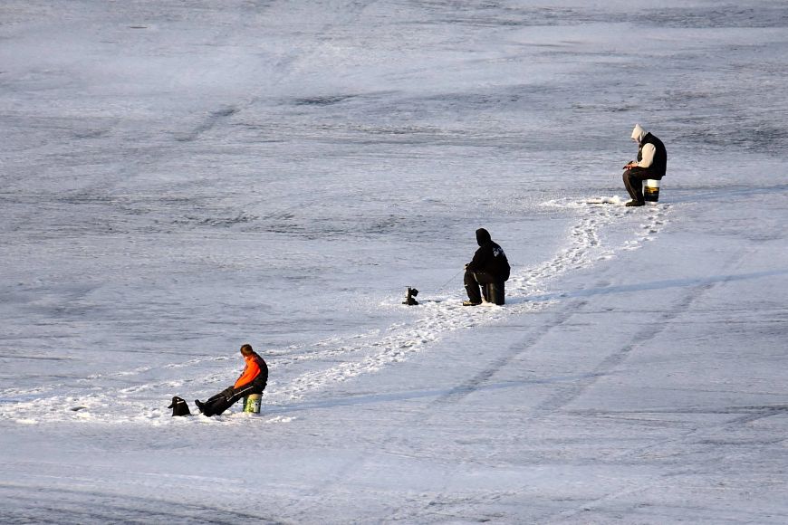 three anglers on frozen ice