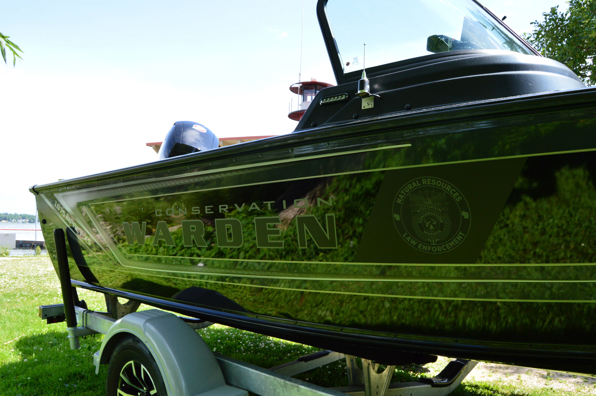 A black boat with the Wisconsin DNR Warden decal on the side.
