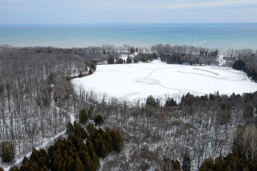 An aerial view of the lake at Harrington Beach State Park in the winter