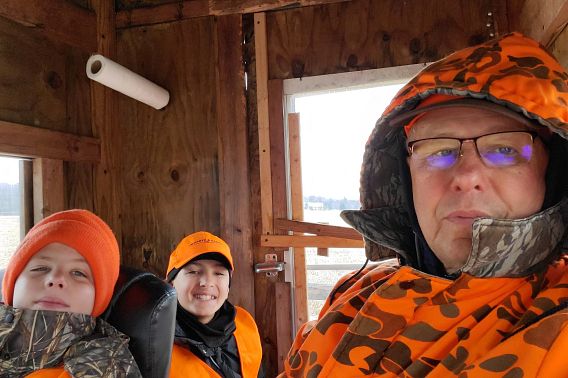 man in hunting blind with two grandkids